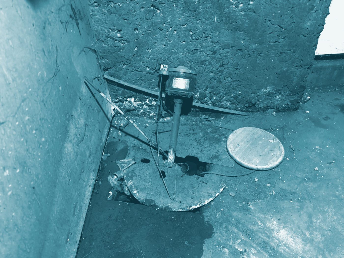 A sump pit in a basement floor